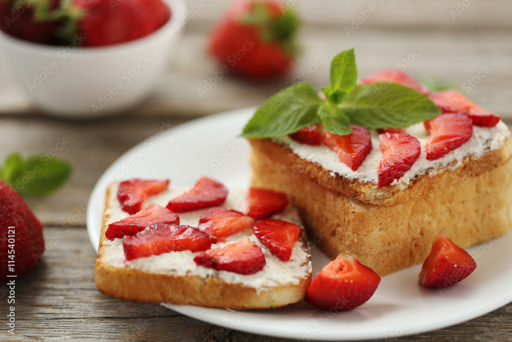French toasts with cream cheese and strawberry on wooden table French toasts with cream cheese and strawberry on wooden table