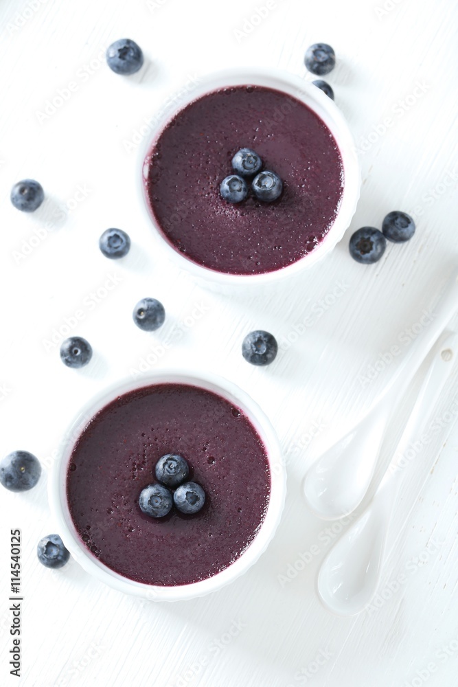 Delicious blueberry mousse in bowls on wooden table Delicious blueberry mousse in bowls on wooden table