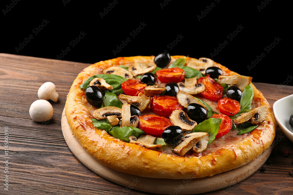 Delicious tasty pizza with ingredients on wooden table Delicious tasty pizza with ingredients on wooden table