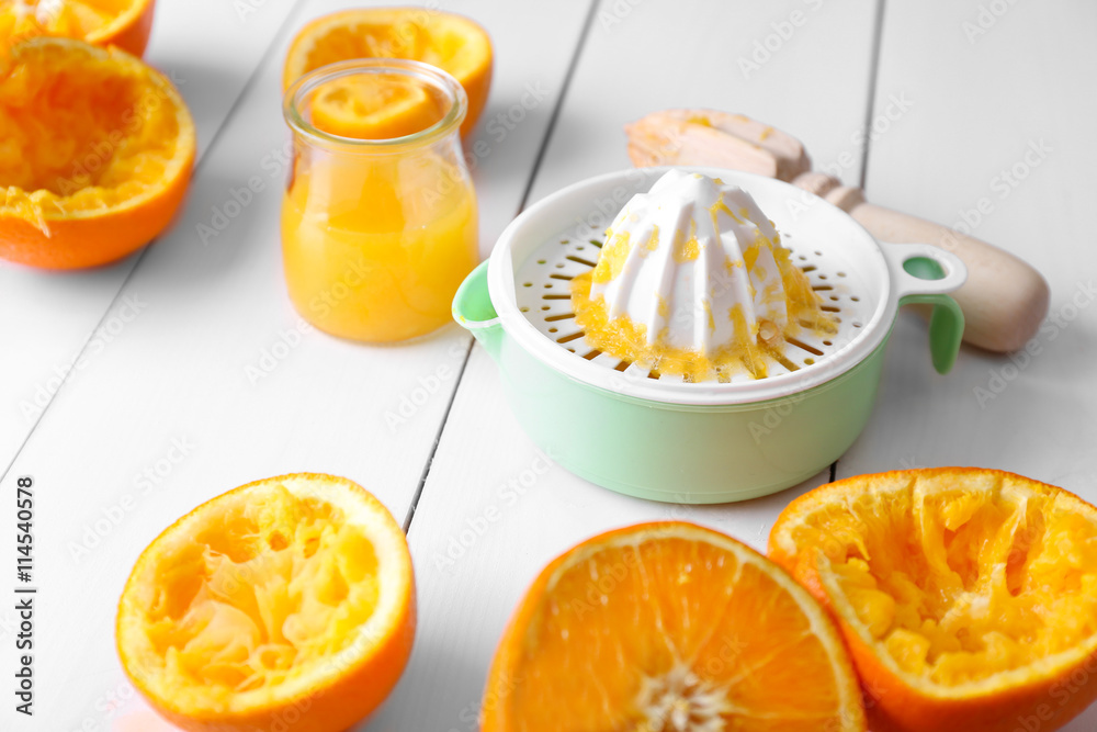 Juicing delicious oranges on white wooden table Juicing delicious oranges on white wooden table