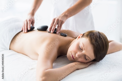 Relaxed woman receiving hot stone massage