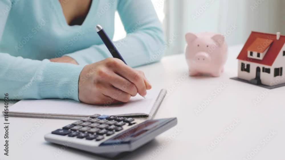 woman counting on calculator and taking notes