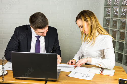 young business colleagues discussing work on a laptop computer in co-working space, corporate businesspeople