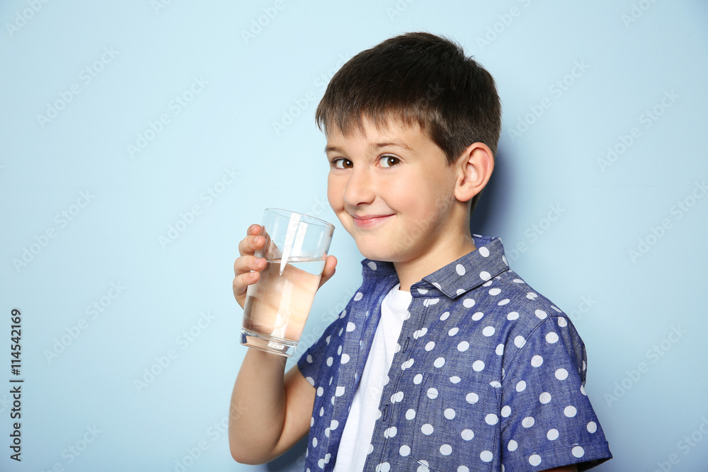 Cute boy drinking water on light background Cute boy drinking water on light background