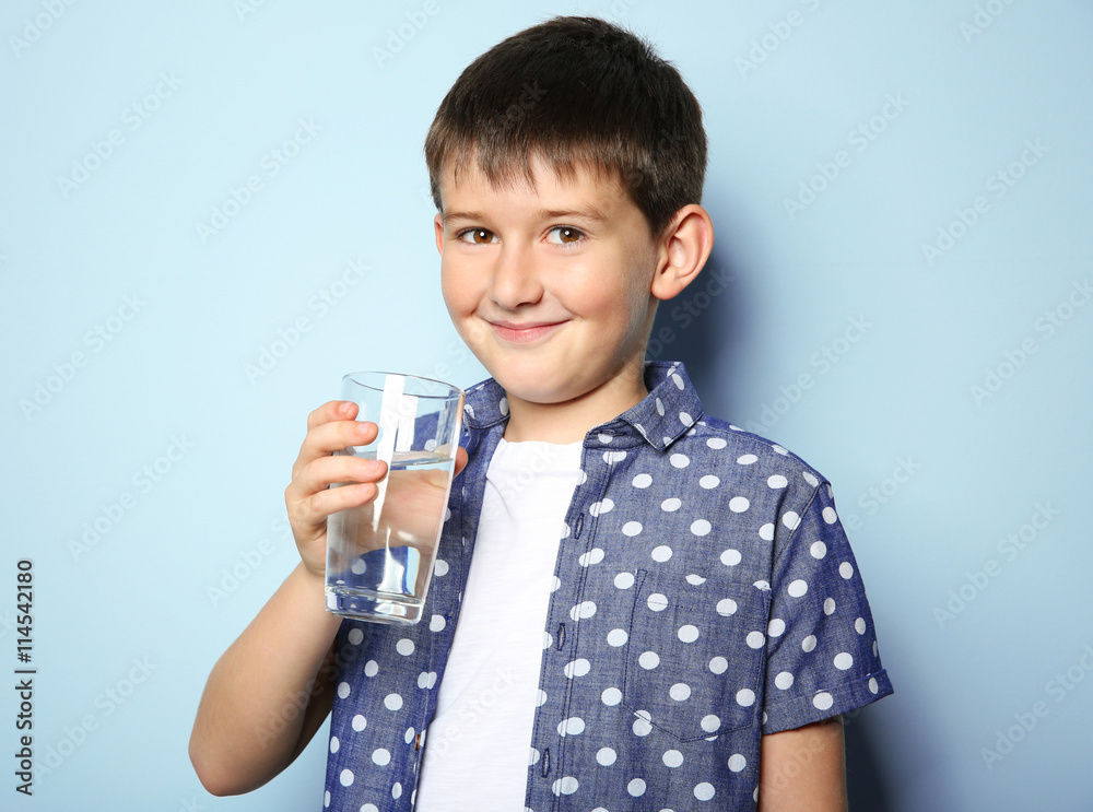 Cute boy drinking water on light background Cute boy drinking water on light background