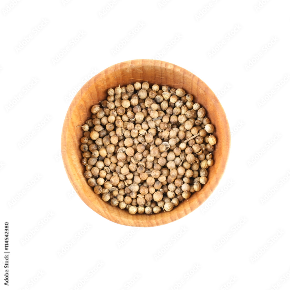 Coriander seeds in small wooden bowl isolated on white Coriander seeds in small wooden bowl isolated on white