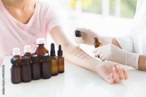 Cropped image of doctor dropping medicine on patient hand