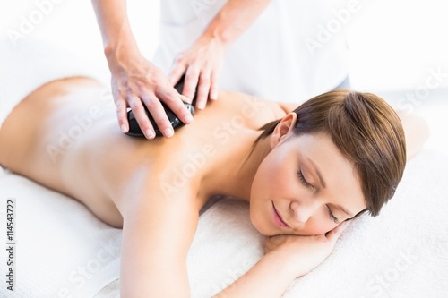Beautiful woman enjoying hot stone massage
