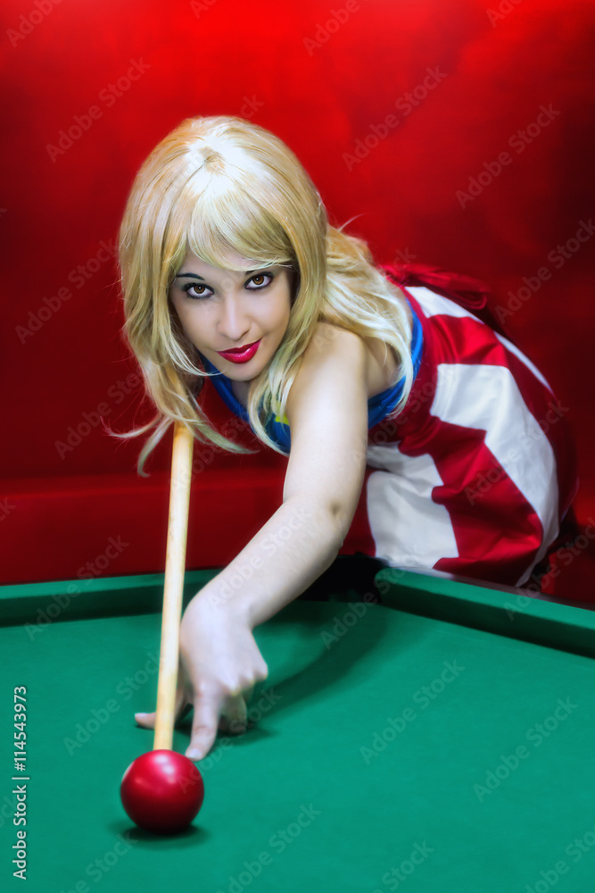 Pin-up and billiards. Blonde girl in pin-up style plays to the pool table.  Stock Photo | Adobe Stock
