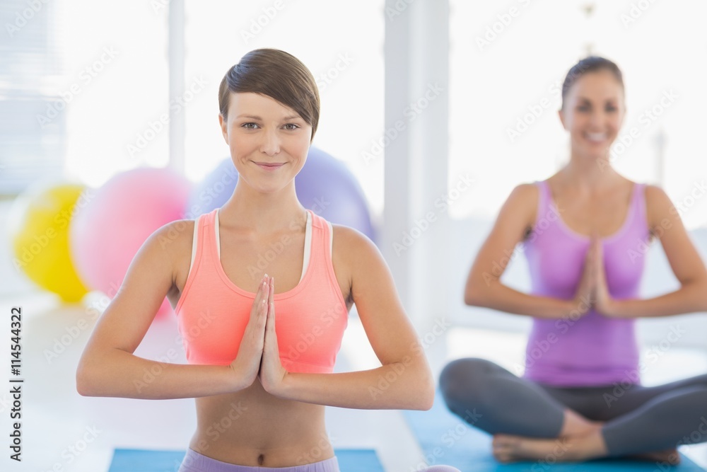 Smiling women exercising at fitness studio
