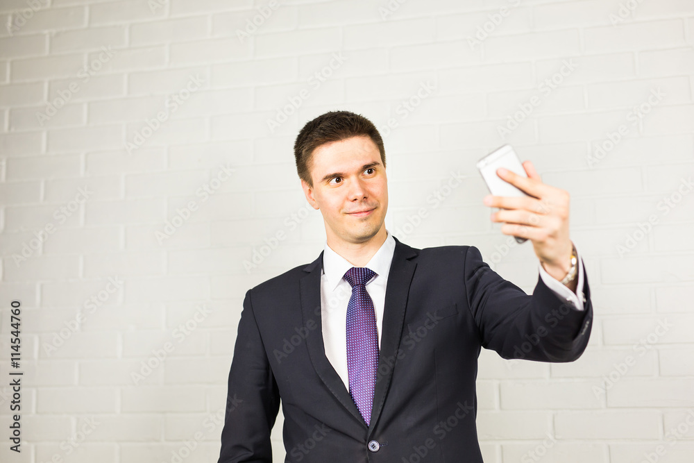 Happy handsome businessman taking selfie in office Happy handsome businessman taking selfie in office