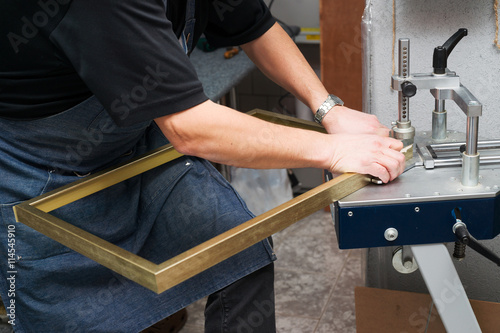 Craftsman working on frame in frameshop.