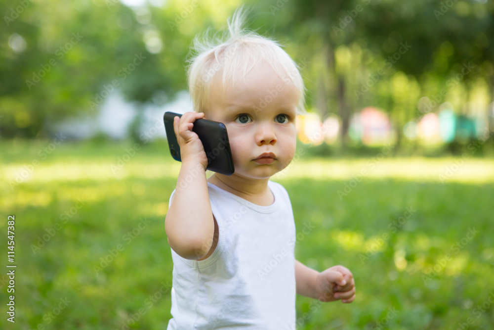the small child plays with the mobile phone
the small child plays with the mobile phone