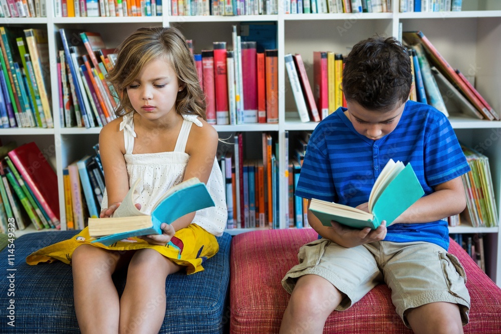 Elementary students reading books in school library Elementary students reading books in school library