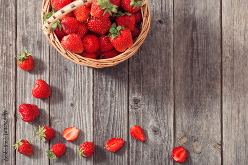 strawberries in basket on wooden background