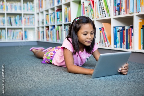Girl using digital tablet in school library