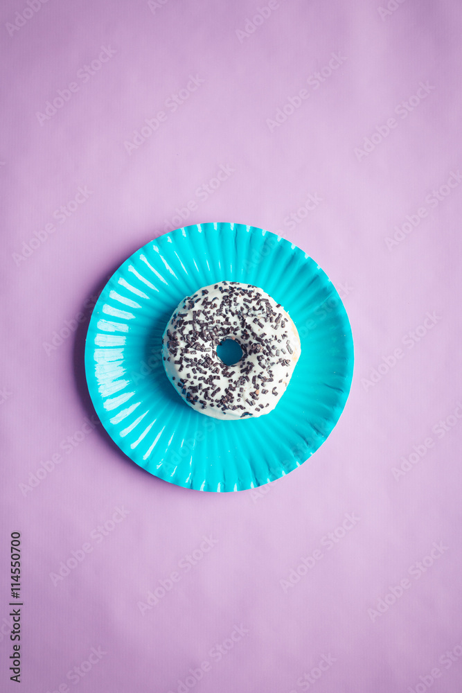 Obraz premium donut with chocolate, top view, colored background