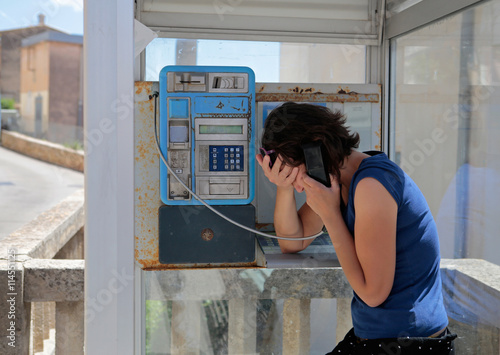 chica llorando en cabina telefónica