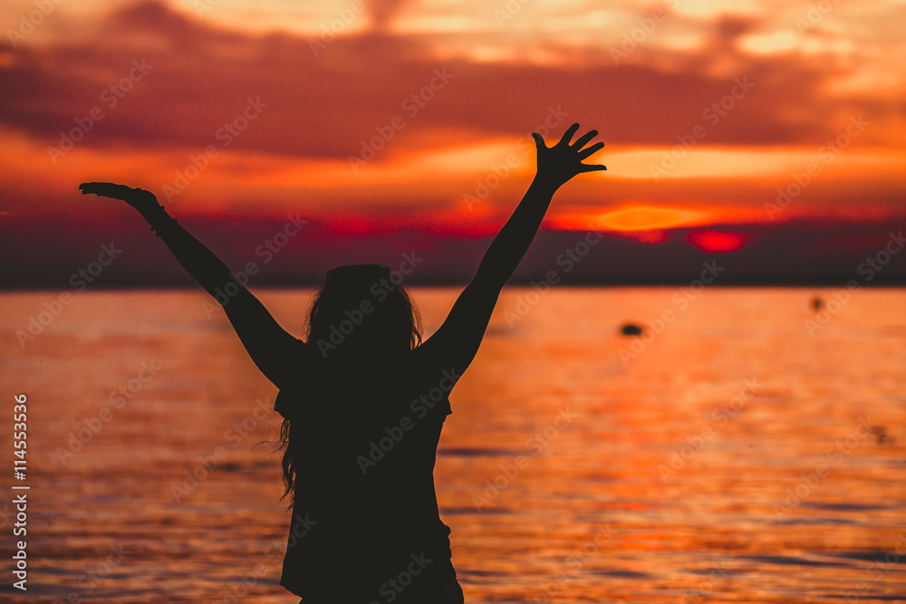 Obraz premium Happy Woman opening hands to sunset