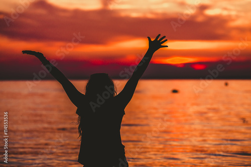 Happy Woman opening hands to sunset
