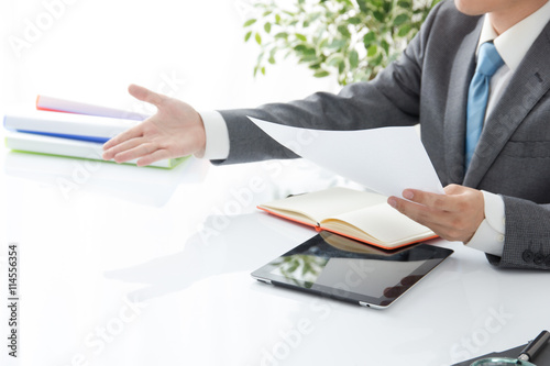 資料を提示する男性サラリーマン