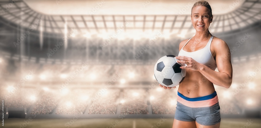 Fototapeta premium Composite image of female athlete holding a soccer ball