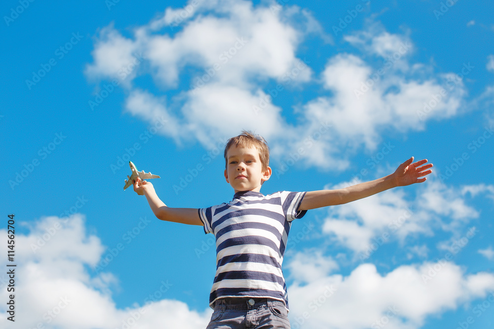 boy playing with toy airplane. happy child with a plane in the hand against a blue sky. copy space for your text boy playing with toy airplane. happy child with a plane in the hand against a blue sky. copy space for your text