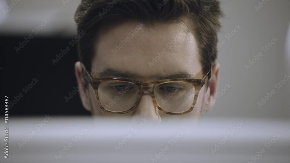 Young man working on computer in office Young man working on computer in office