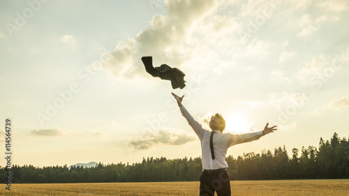 Happy Successful Businessman Throwing His Coat in the Air photo