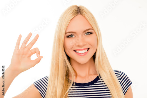 Portrait of happy cheerful girl showing OK gesture