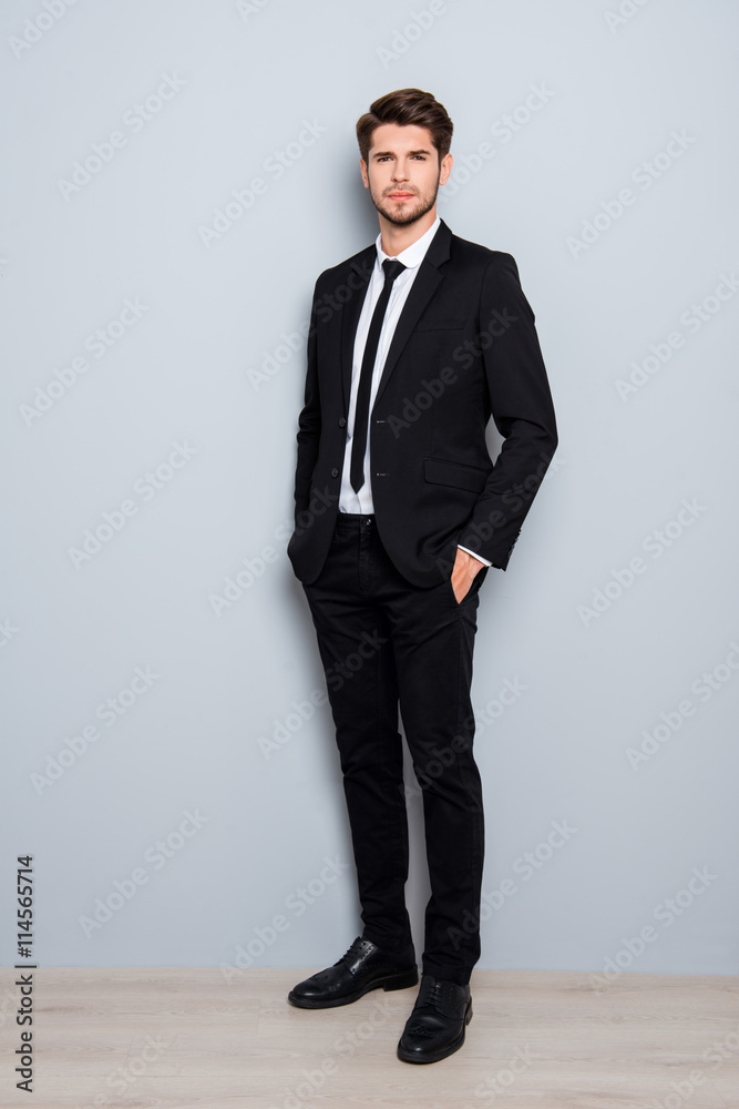 Full length portrait of handsome man in suit holding hands in po Full length portrait of handsome man in suit holding hands in po