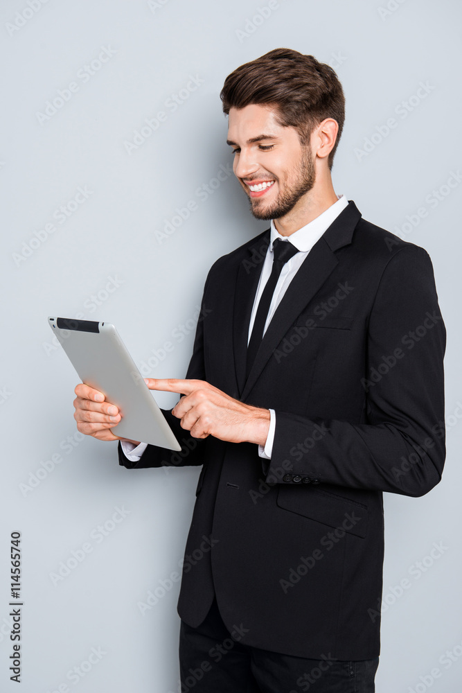 Cheerful businessman in suit touching screen of tablet Cheerful businessman in suit touching screen of tablet