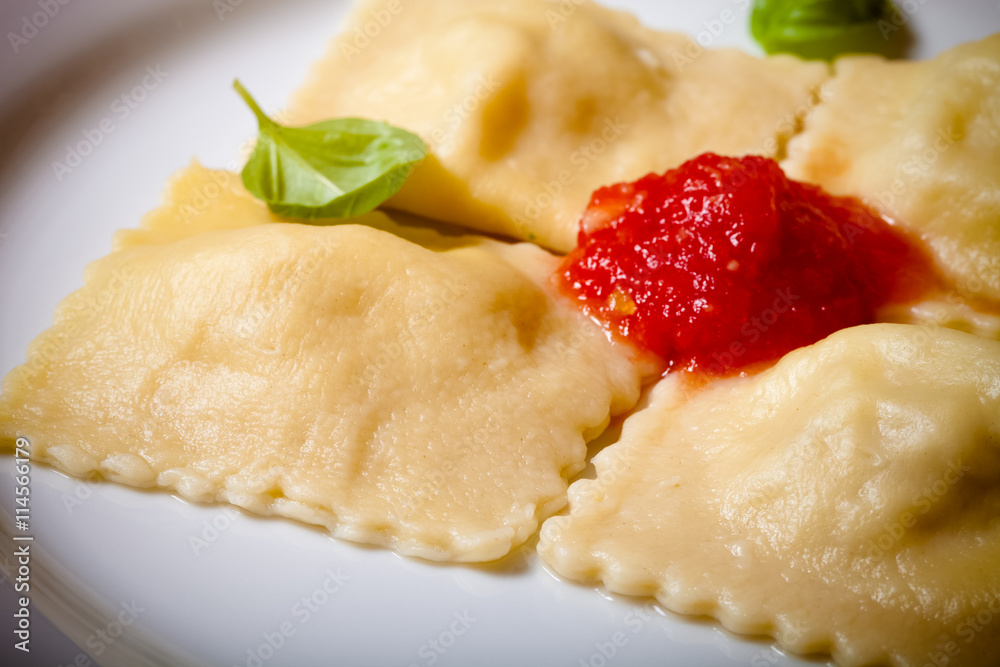 Russian ravioli - pelmeni with tomato sauce and basil on a white Russian ravioli - pelmeni with tomato sauce and basil on a white