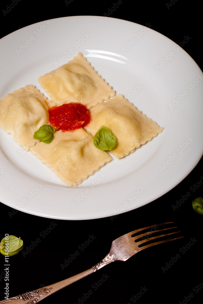 Russian ravioli - pelmeni with tomato sauce and basil on a white Russian ravioli - pelmeni with tomato sauce and basil on a white