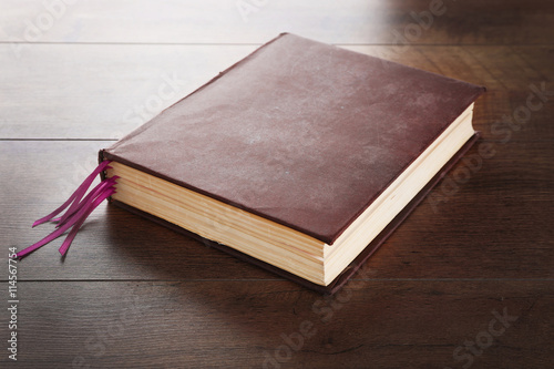 Notebook with bookmarks on wooden background