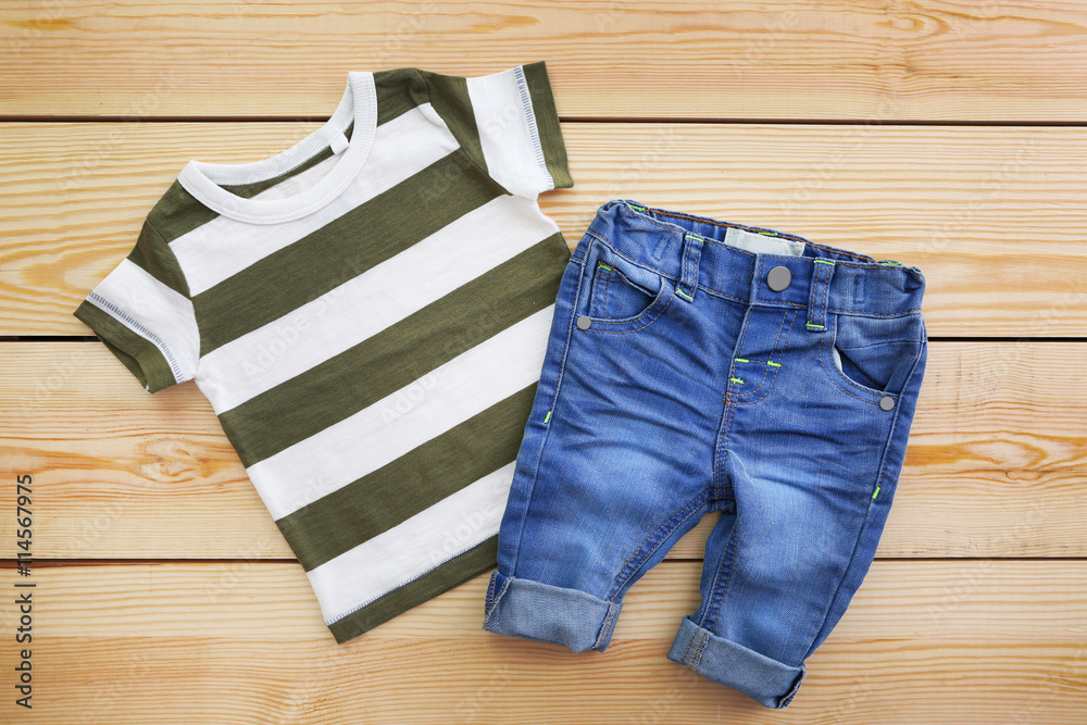 New baby clothes on wooden background New baby clothes on wooden background