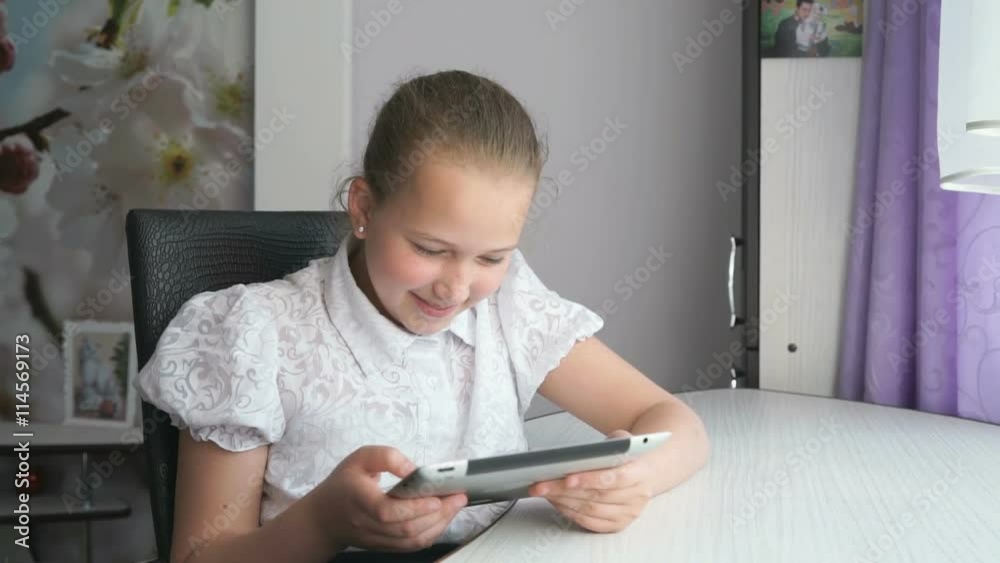 Cute little girl uses a digital tablet computer Cute little girl uses a digital tablet computer