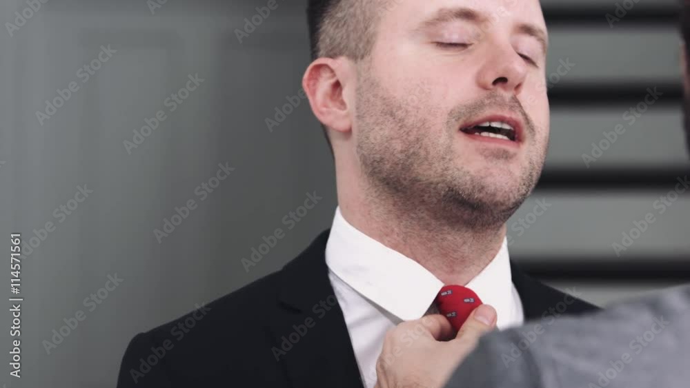 One adult man adjusting tie to his partner