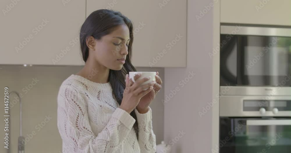 Woman smelling and drinking coffee in kitchen Woman smelling and drinking coffee in kitchen