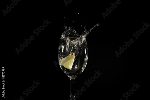 Toss fruit into a glass of splash water and black background