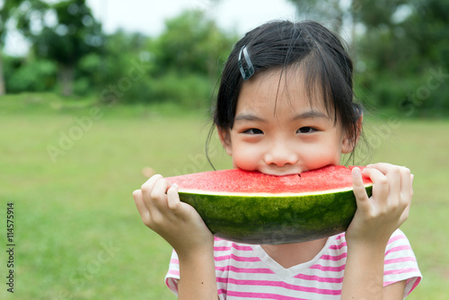 Asian child eating watermelon