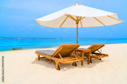 Outdoor daybed on a tropical beach with white sunshade. © twenty2photo