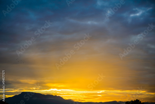 Sunrise in cloudscape over mountains