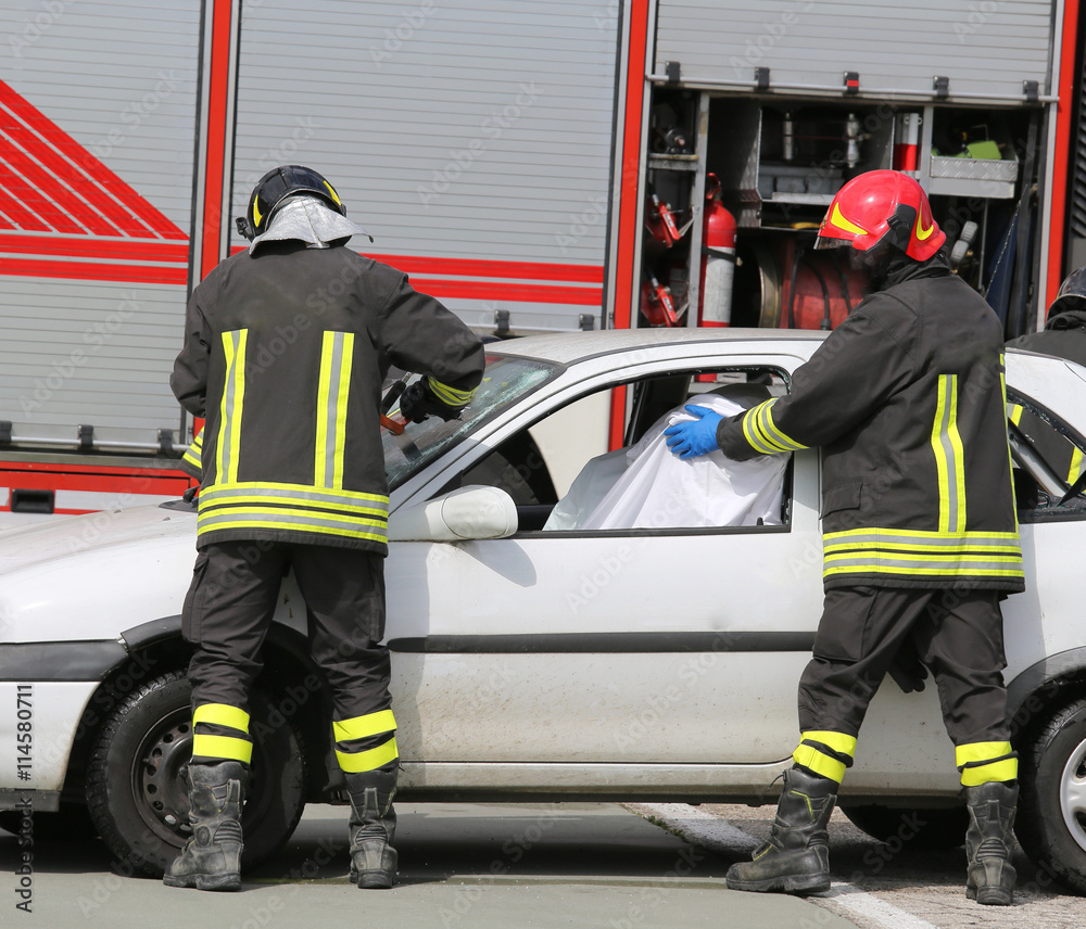 Firefighters while saving the wounded in the damaged car Firefighters while saving the wounded in the damaged car