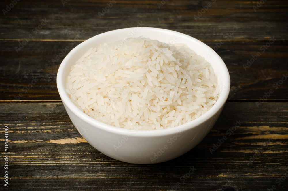  Rice seed in the bowl on wooden background