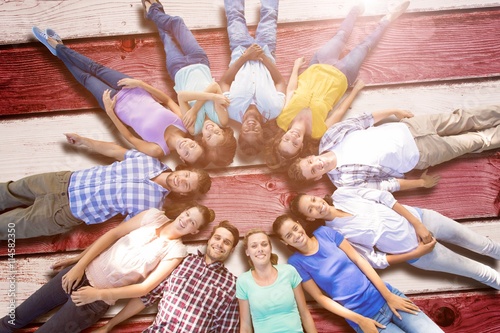 Composite image of happy friends lying in circle
