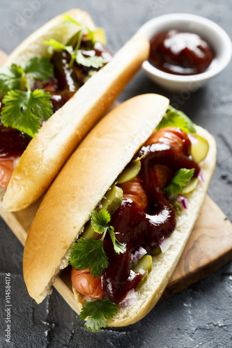 Hot dog with pickled cucumber, red onion and barbecue sauce