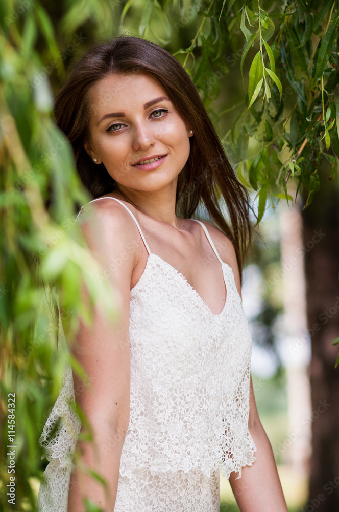Beautiful young woman in romantic dress relaxing in garden Beautiful young woman in romantic dress relaxing in garden