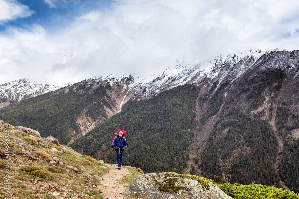 Woman mountain Hiker with backpack enjoy view in Caucasus mountains, Elbrus region, Russia.