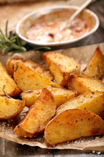 Roasted potatoes with dip on wooden table
